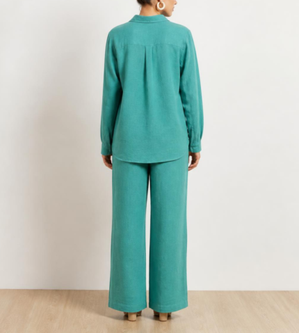 Back view of woman's turquoise linen co-ord set showing button-down shirt and wide-leg trousers