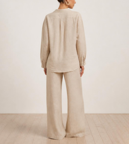 Close-up back view of woman's beige linen co-ord set showing collared button-down shirt and wide-leg trousers