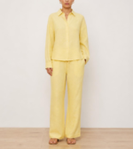 Woman wearing a butter yellow linen co-ord set with button-down shirt and wide-leg trousers, front view