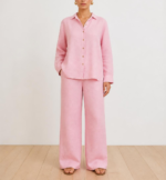 Woman wearing a pink linen co-ord set with button-down shirt and wide-leg trousers, front view