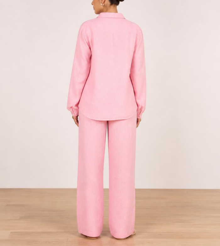 Back view of woman's pink linen co-ord set showing button-down shirt and wide-leg trousers